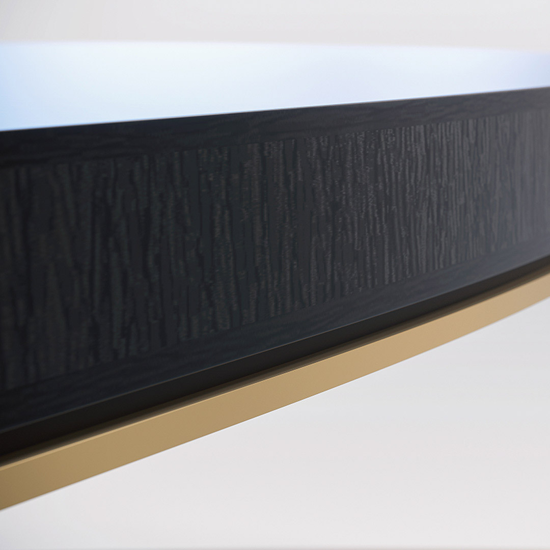 A contemporary dining table in a sycamore black with a shadow gap and brushed brass trim detail to the frieze.