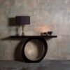 A contemporary console table with an edgy, asymmetric slant. Finished in a dark tinted Macassar ebony with the inside pedestal hand gilded in a distressed white gold leaf.
