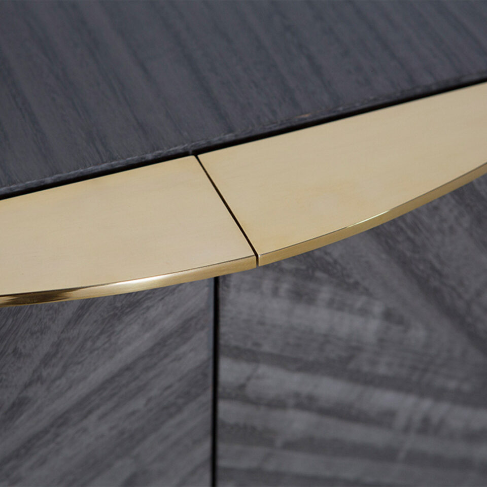 A sleek sideboard finished in a high gloss metallic grey eucalyptus with a glamorous handle in polished brass that sits flush to this cabinet