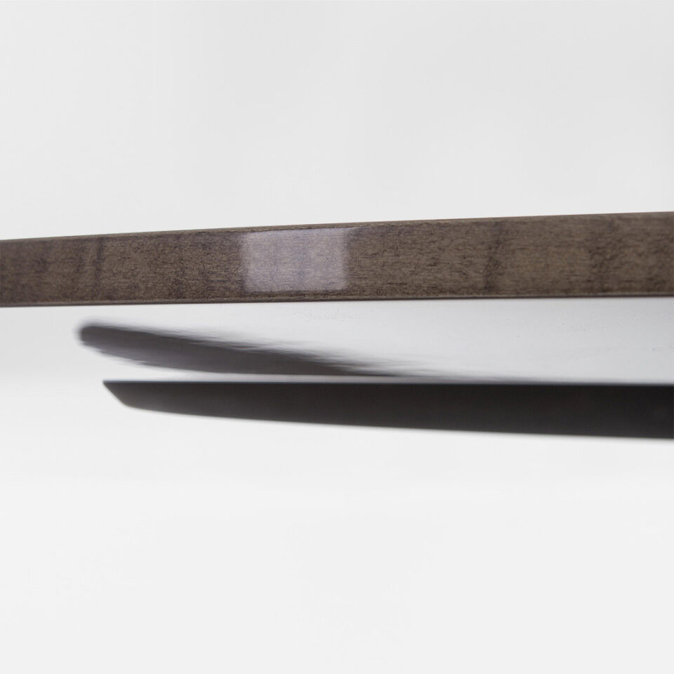 A luxurious round dining table with a slimline tabletop finished in a high gloss sycamore dusk