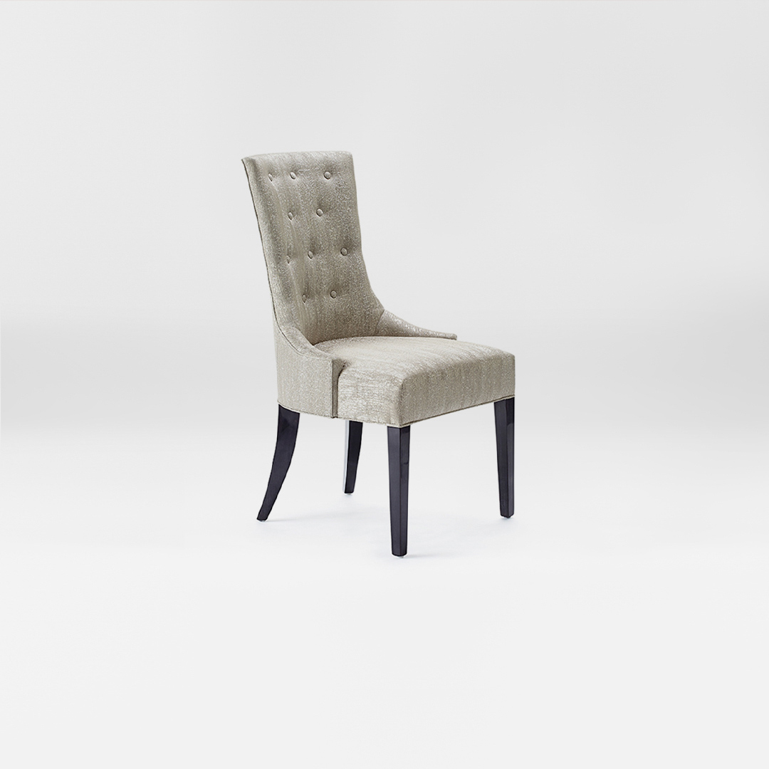 A luxury Dining chair with a high back and button detailing. Upholstered in a soft silver fabric with satin tinted beech legs. Design by DAVIDSON London. Side view.