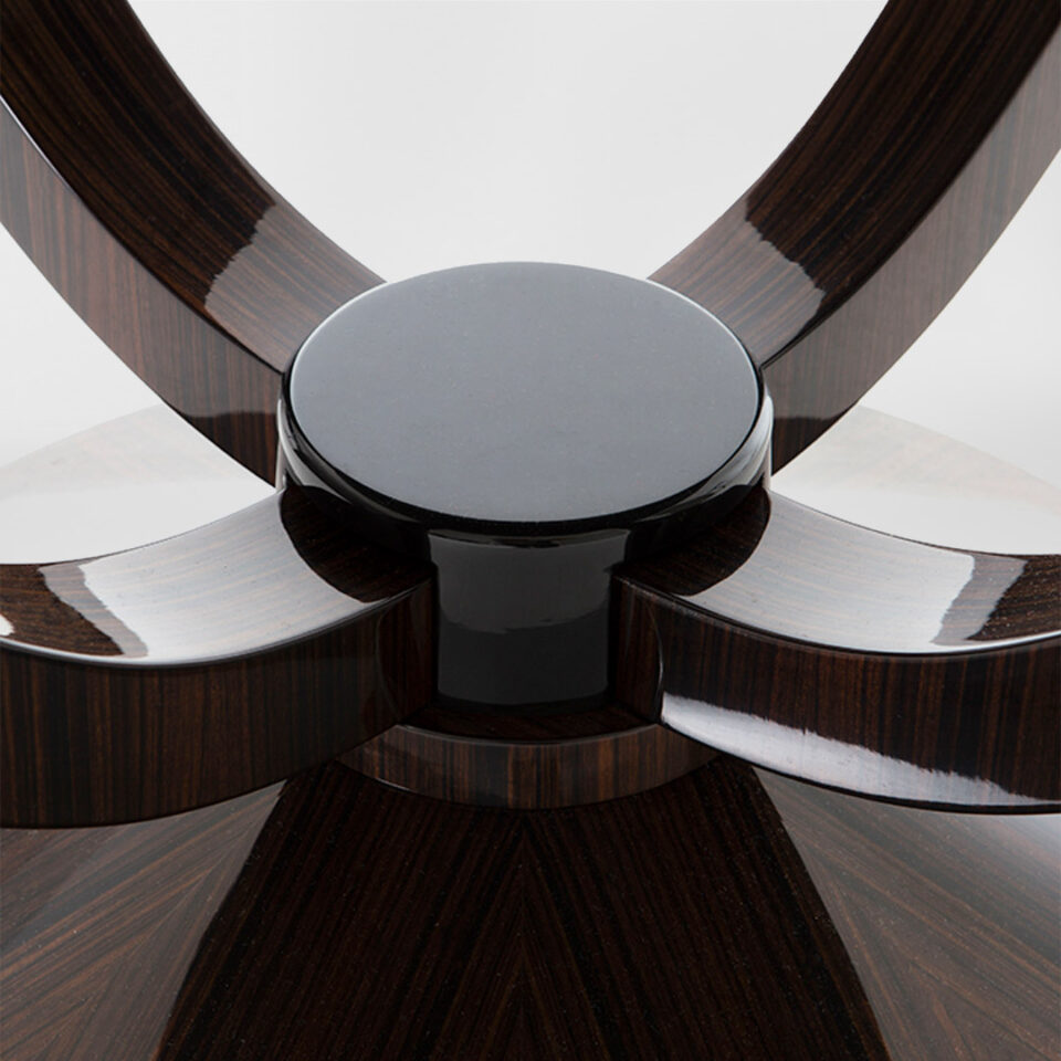 A closeup detail of the Hester pedestal in a high gloss Macassar Ebony with four gently-curved legs anchored at the base with an ebonised block.