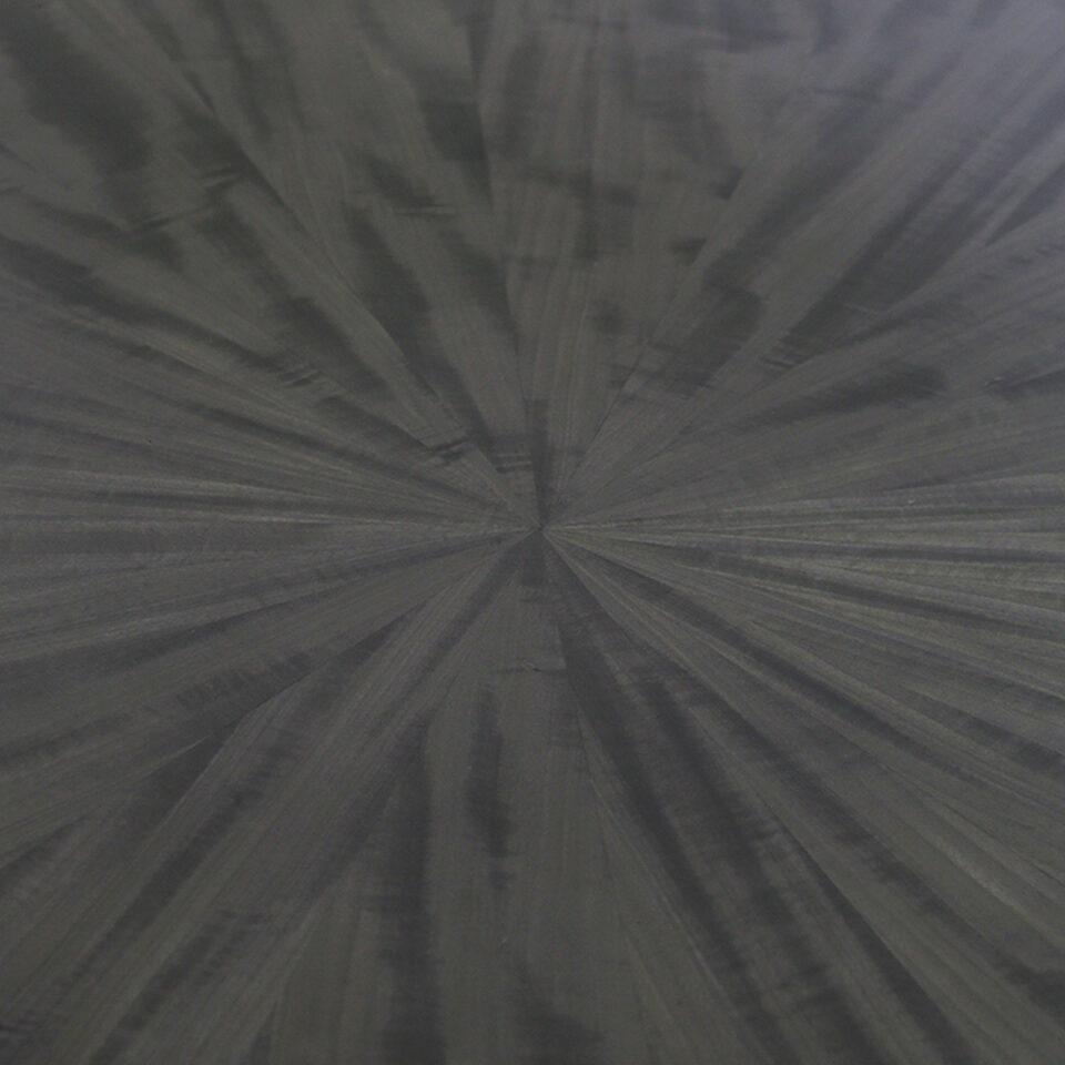 A detail tabletop image of this glamorous dining table finished in a pebble grey anegre with a striking radial pattern