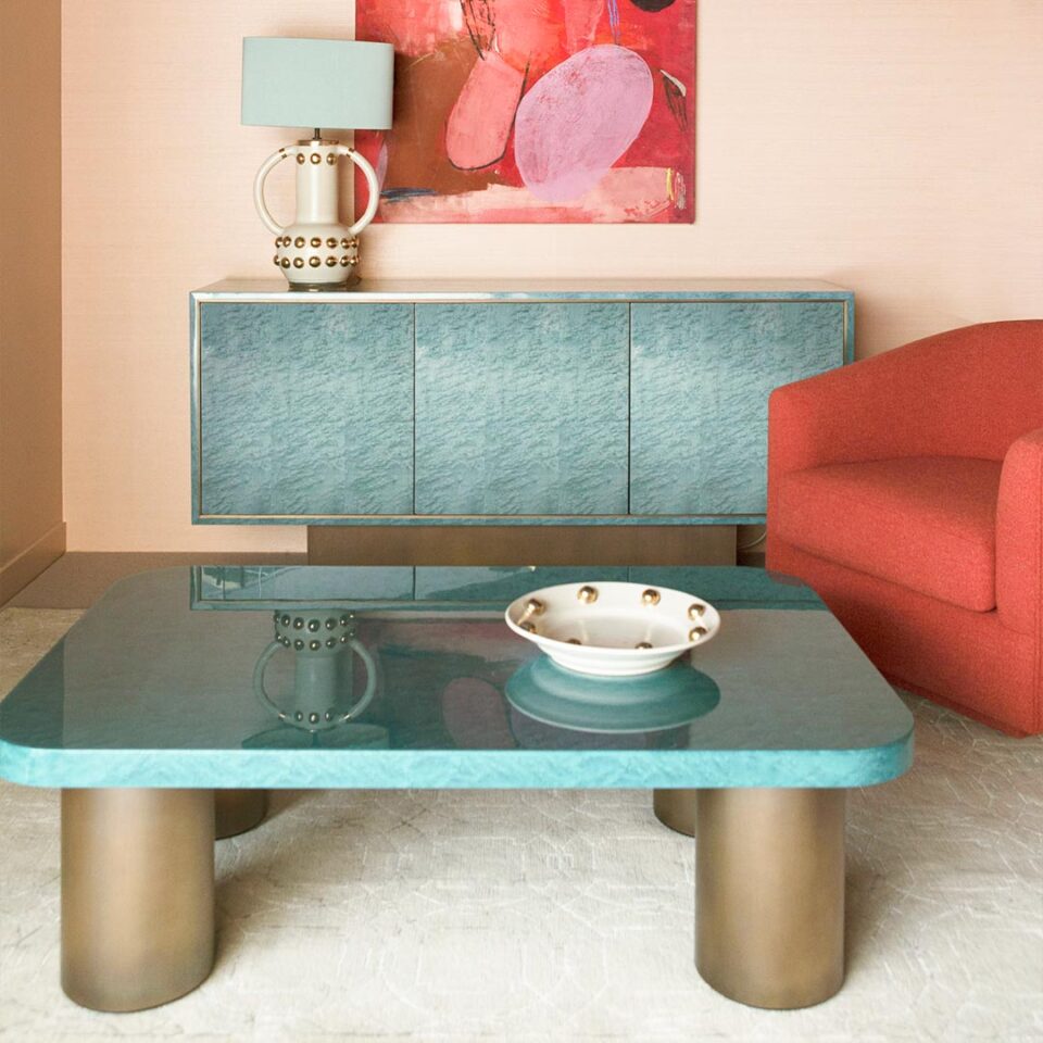 The Palisades Sideboard and Malibu Coffee Table in high gloss birdseye maple with antiqued brushed brass trim and the Boulevard armchair upholstered in a red wool fabric