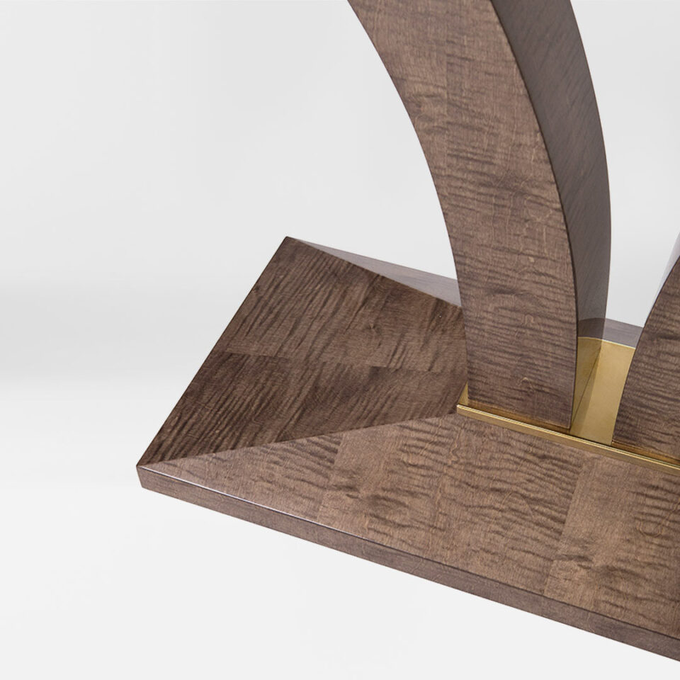 An elegant console table, pedestal detail in sycamore dusk with a luxurious metal collar in brushed brass