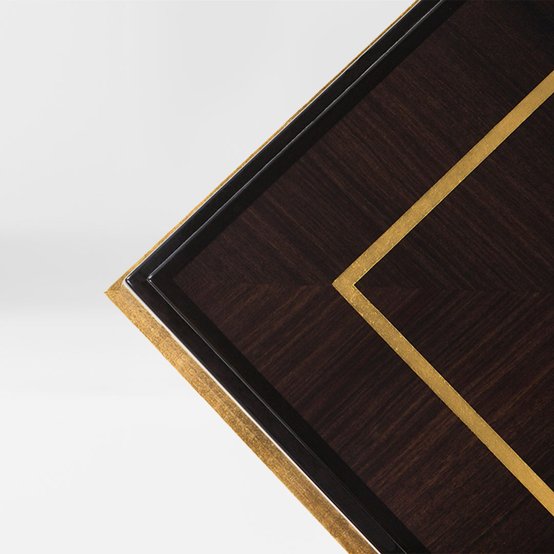 A sleek dark coffee table in a Macassar ebony finished with a gilded moon gold leaf edging and inlay