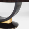A graceful oval dining table finished in a high gloss dark tinted Macassar ebony with hand gilded yellow gold leaf detail to the pedestal.