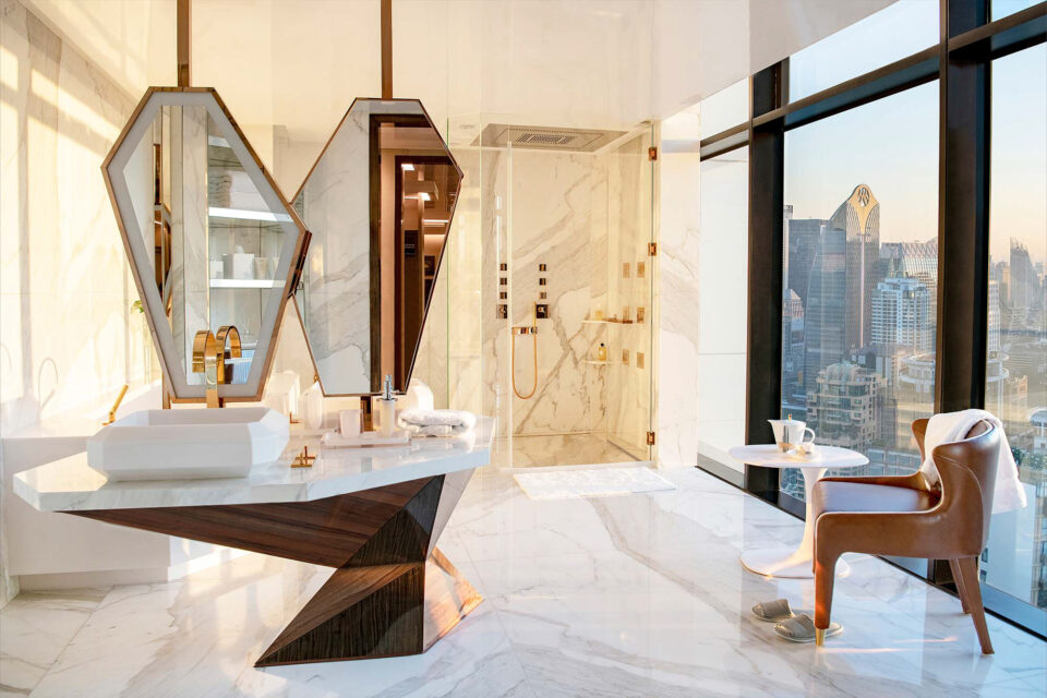 The master bathroom overlooks the Bangkok skyline and is finished with large, sculptural marble vanities.