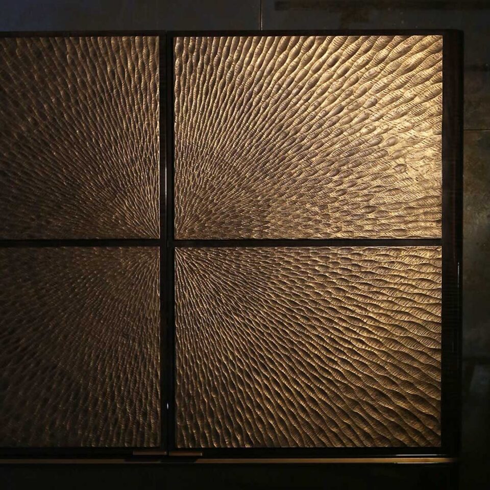 A stylish 2 door drinks cabinet with high gloss sycamore black legs and hand carved liquid bronze doors. Design by DAVIDSONLondon.