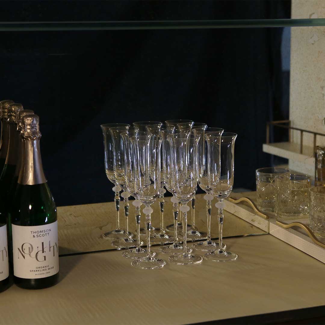 A stylish 2 door drinks cabinet with high gloss sycamore black legs and hand carved liquid bronze doors. Design by DAVIDSONLondon.