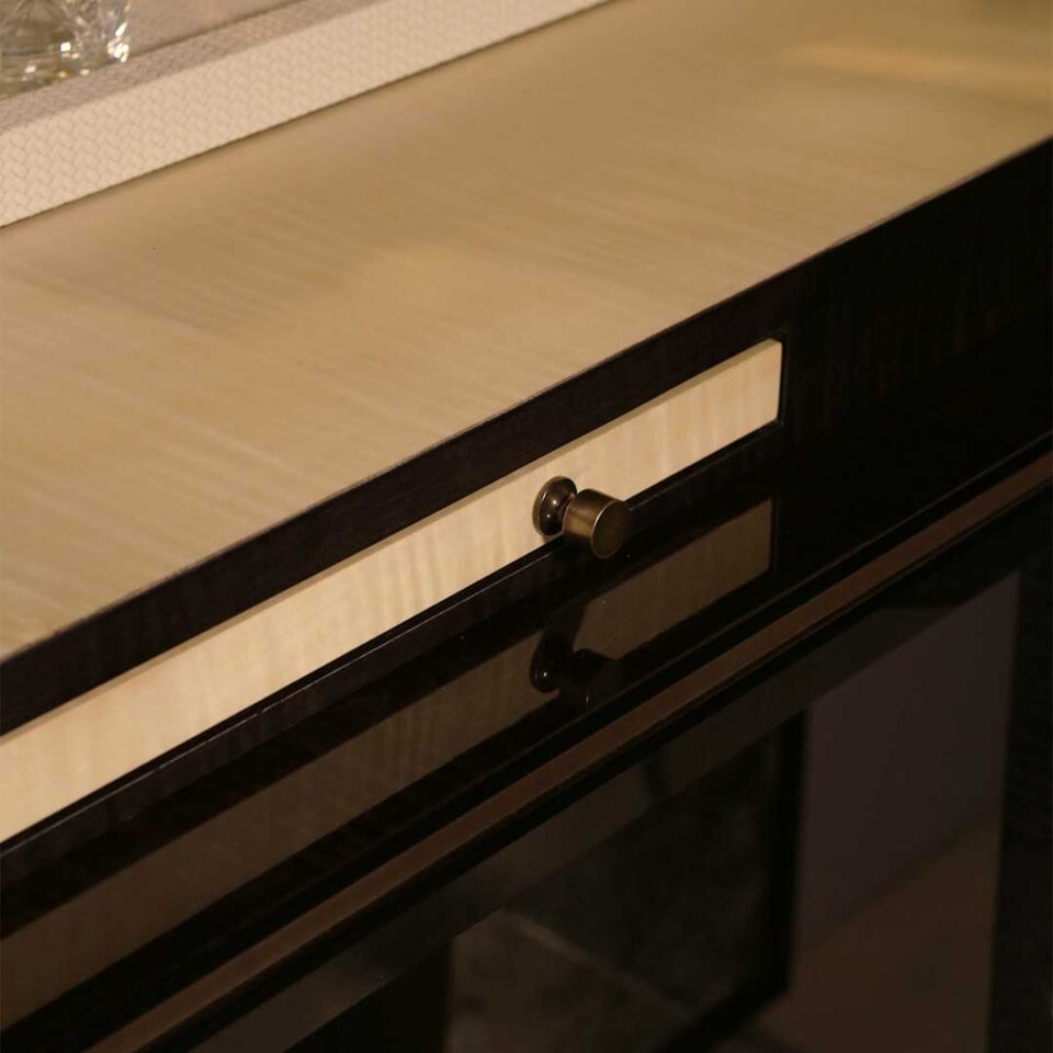 A stylish 2 door drinks cabinet with high gloss sycamore black legs and hand carved liquid bronze doors. Design by DAVIDSONLondon.