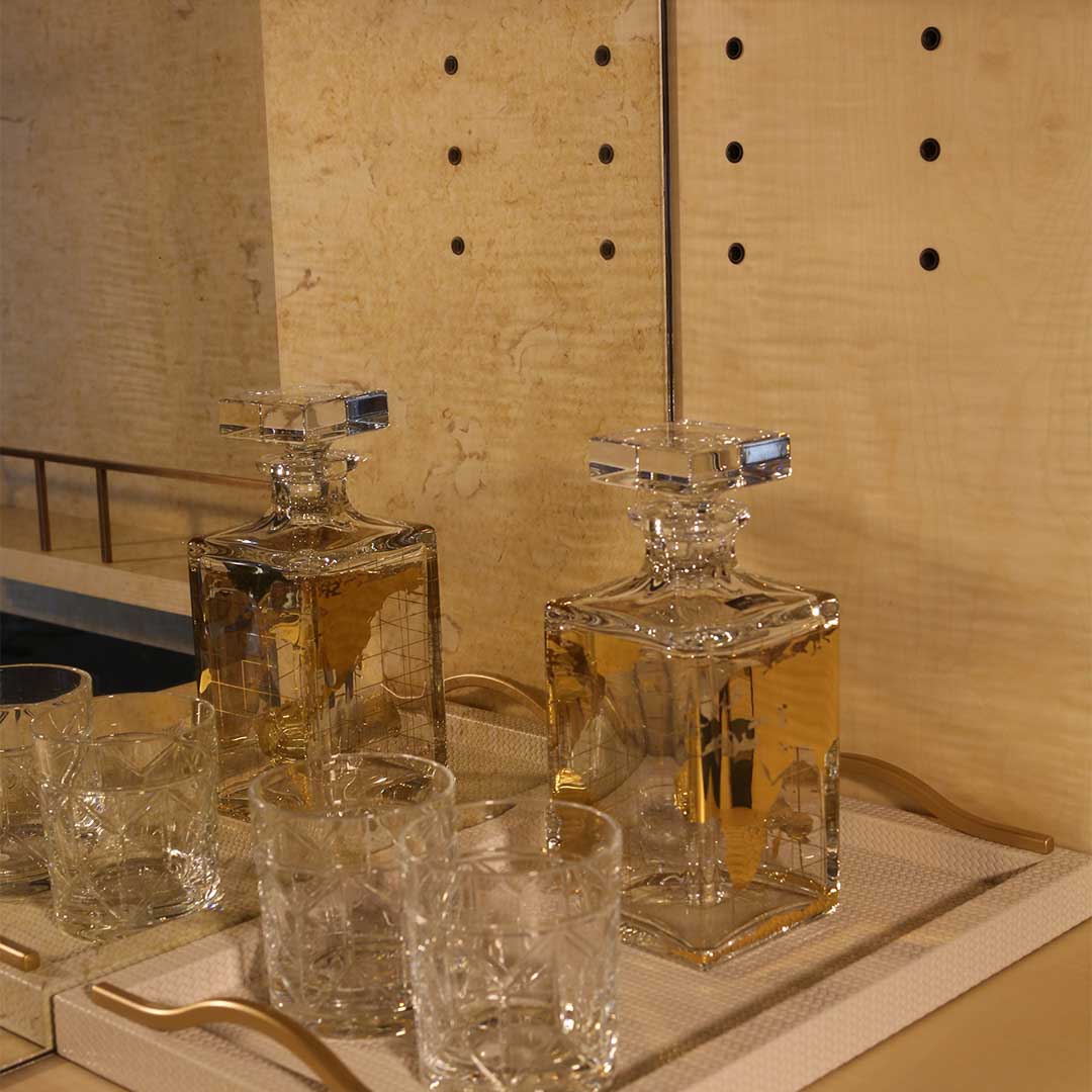 A stylish 2 door drinks cabinet with high gloss sycamore black legs and hand carved liquid bronze doors. Design by DAVIDSONLondon.