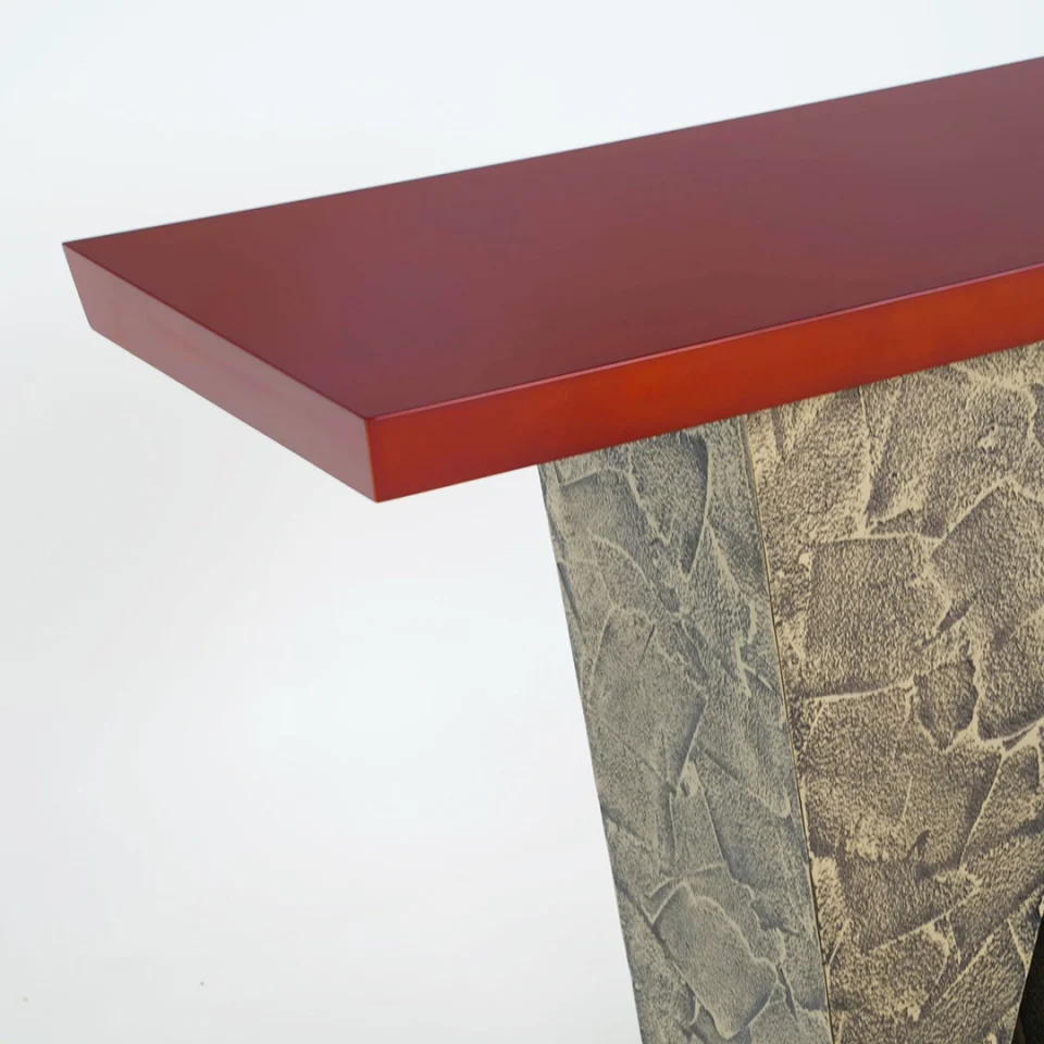 a console table with a distressed bronze base and a red high gloss lacquer top