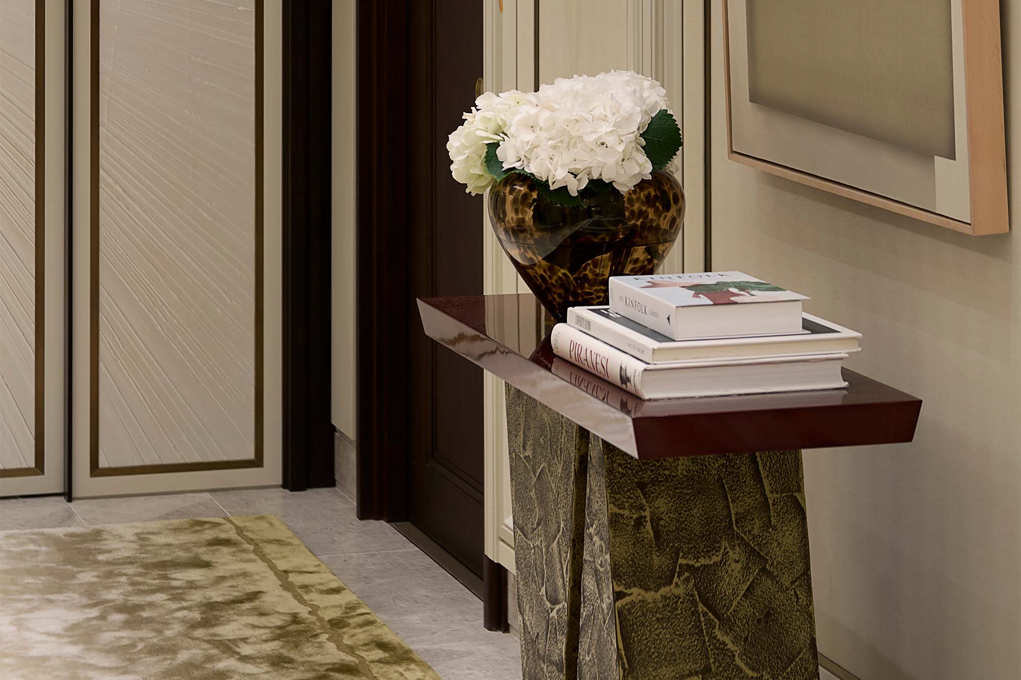 Elegant Hallway that features a console table with a red top and bronze base - A Serene and Artisanal Luxury Home in Mayfair - liquid metal furniture